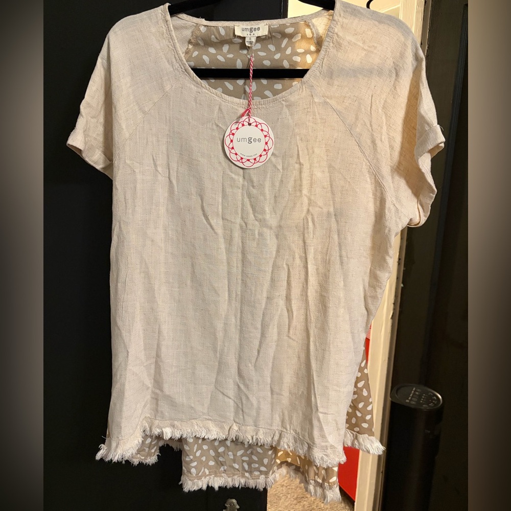 Umgee  linen blend short sleeve top with a frayed hem and an animal print back.